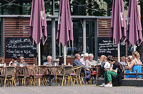 Restaurantterrasse in deutscher Innenstadt mit Tischen und Außengastronomie im öffentlichen Raum