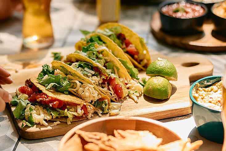 Nahaufnahme von Menschen die in einem mexikanischen Restaurant essen. Foto: © Drazen ZigiciStock/iStock/Getty Images Plus