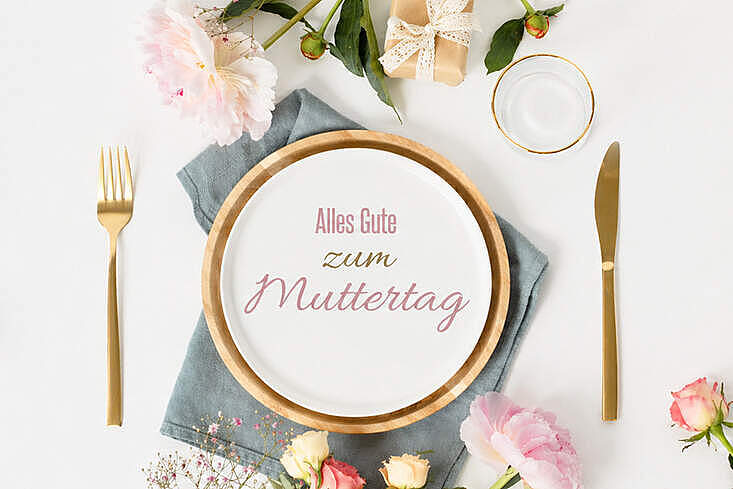 Festlich gedeckter Tisch mit Blumen und Teller zum Muttertag, symbolisch für Restaurantbesuche und gemeinsame Feier in der Gastronomie.