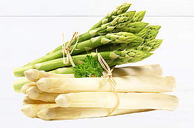 Bündel aus weißem und grünem Spargel auf heller Fläche, frisch geerntet und dekorativ angerichtet, symbolisch für die Frühlingssaison.