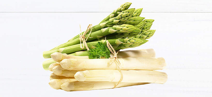 Bündel aus weißem und grünem Spargel auf heller Fläche, frisch geerntet und dekorativ angerichtet, symbolisch für die Frühlingssaison.