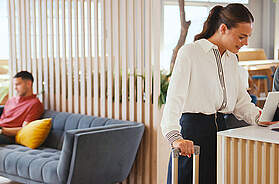 Geschäftsfrau mit Koffer checkt an der Hotelrezeption für Konferenz ein. Foto: monkeybusinessimages/iStock/Getty Images 