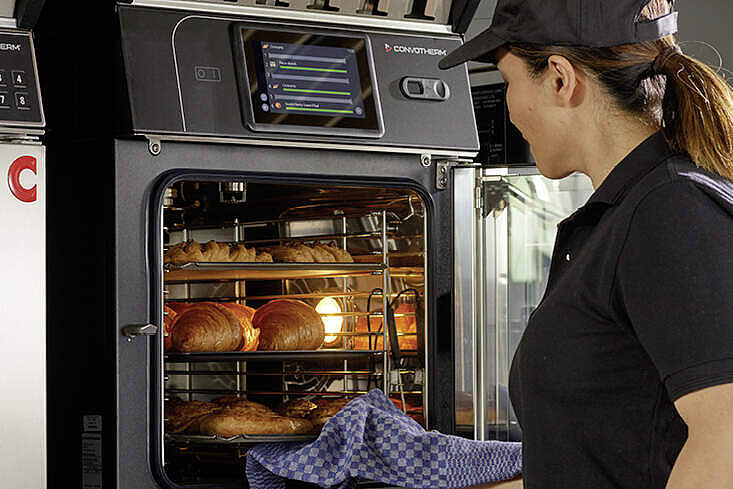 Mitarbeiterin bedient einen Convotherm mini 10.10 Black Edition in einer professionellen Küche.