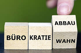 Holzbausteine mit dem Schriftzug „Bürokratieabbau“ als Symbol für Entlastungen im Gastgewerbe durch den Koalitionsvertrag.