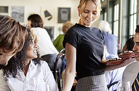 Kellnerin serviert Essen an Business Kollegen Sitzen am Restaurant Tisch - Stock-Fotografie Foto: © Monkeybusinessimages / iStock / Getty Images Plus