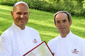 Karl und Rudolf Obauer präsentieren eine Auszeichnung im Freien. Das Brüderpaar führte das mehrfach ausgezeichnete Restaurant-Hotel Obauer in Werfen im Salzburger Land, das im Oktober 2026 schließen wird.