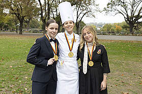 Die Deutschen Jugendmeisterinnen 2026: Hotelfachfrau Pia-Emily Kittel (l.) vom Hotel Waldkrug, Delbrück (Nordrhein-Westfalen), Köchin Katharina Möhrle vom Wellness Hotel Tanne Tonbach, Baiersbronn (Baden-Württemberg), und Luca Kleinbauer, Fachfrau für Restaurants und Veranstaltungsgastronomie, vom La Maison Hotel, Saarlouis (Saarland). Foto: DEHOGA/Thomas Fedra