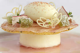 Filigran angerichtetes Dessert von Vivien Steinmair mit Rhabarber, weißer Schokolade und Thymian auf hellem Teller.