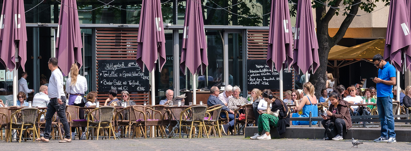 Restaurantterrasse in deutscher Innenstadt mit Tischen und Außengastronomie im öffentlichen Raum