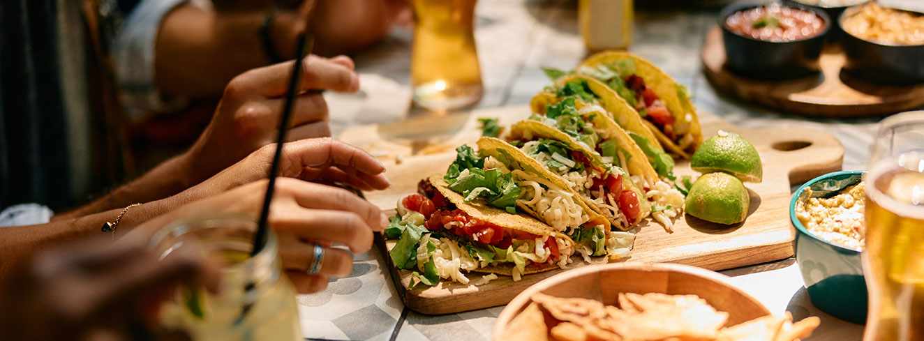 Nahaufnahme von Menschen die in einem mexikanischen Restaurant essen. Foto: © Drazen ZigiciStock/iStock/Getty Images Plus