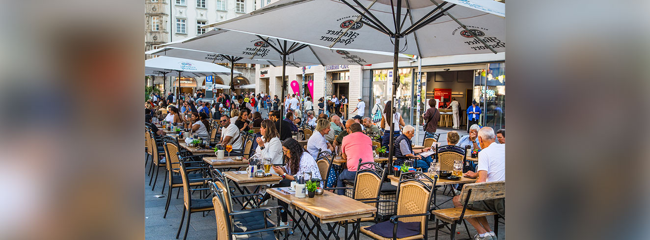 München, Straßenszene am Frauenplatz in München, mit Leuten, die auf Terrassen der Außenrestaurants essen und Bier trinken - Stock-Fotografie-Foto: © IR_Stone / iStock/ Getty Images