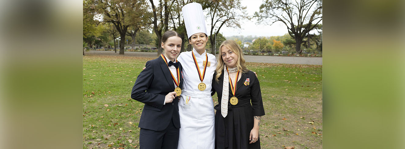 Die Deutschen Jugendmeisterinnen 2026: Hotelfachfrau Pia-Emily Kittel (l.) vom Hotel Waldkrug, Delbrück (Nordrhein-Westfalen), Köchin Katharina Möhrle vom Wellness Hotel Tanne Tonbach, Baiersbronn (Baden-Württemberg), und Luca Kleinbauer, Fachfrau für Restaurants und Veranstaltungsgastronomie, vom La Maison Hotel, Saarlouis (Saarland). Foto: DEHOGA/Thomas Fedra